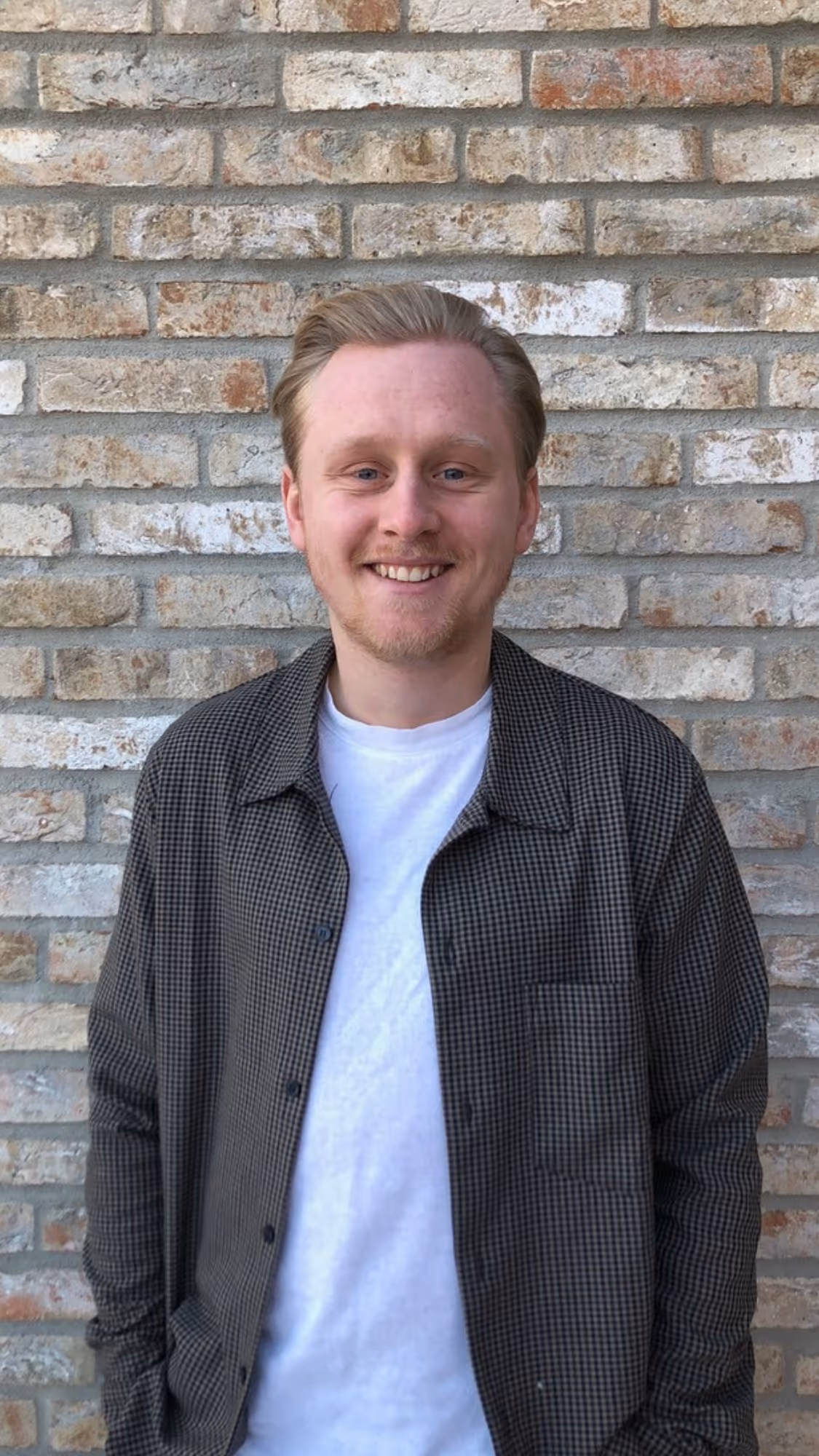 A man in front of a grey decorative background
